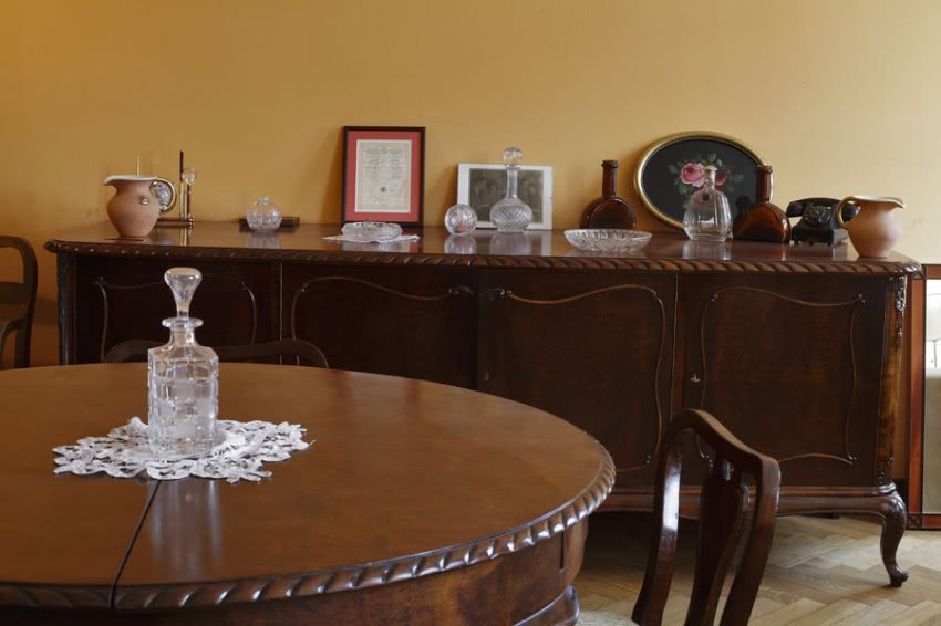 Na komodzie barwny miks bibelotów: obok...