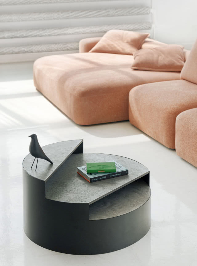 czarny stolik kawowy, sofa, figurka ptaka, książki, grzejnik