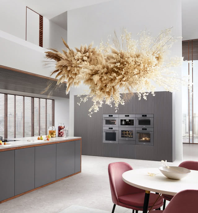 Szary aneks kuchenny z naturalną lampą wiszącą