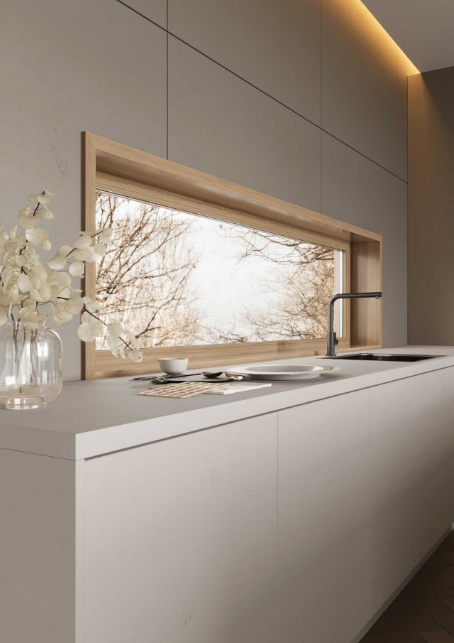 Nowoczesny blat kuchenny z oknem w drewnianej ramie i frontami RAUVISIO CUBE w odcieniu jasnoszarego betonu