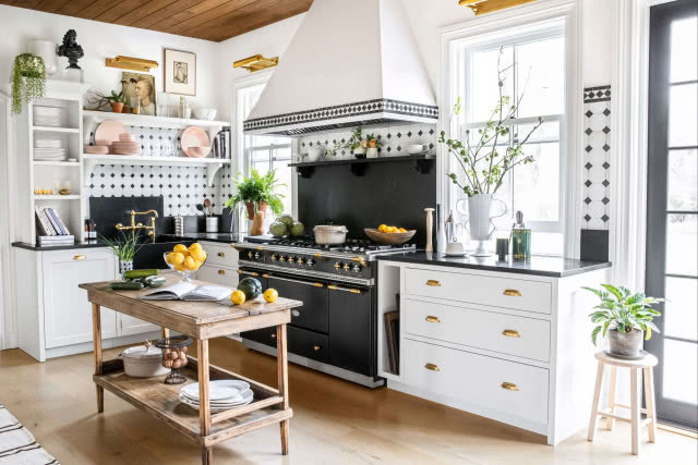 biała kuchnia z czarną kuchenką i płytkami