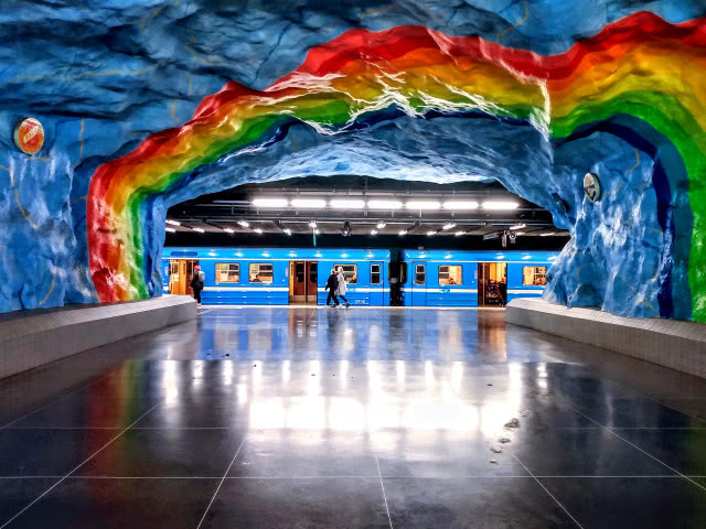 widok na peron przez sklepienie skalne pomalowane w tęczę