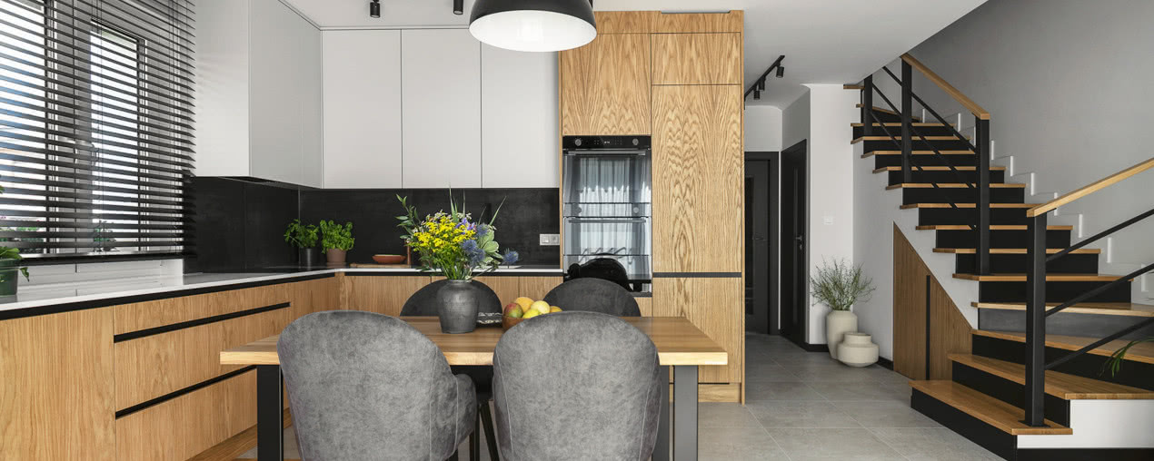 Drewno, czerń i szarość - wnętrza domu pełne spokoju