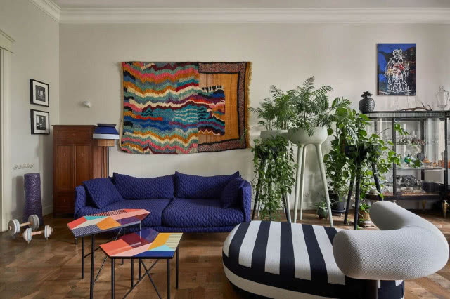 granatowa sofa szezlong gobelin na ścianie