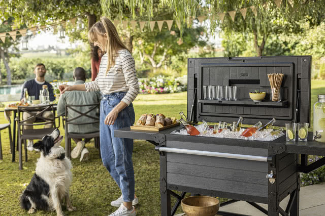 Barek ogrodowy z chłodzonymi napojami podczas letniego garden party w zielonym ogrodzie.