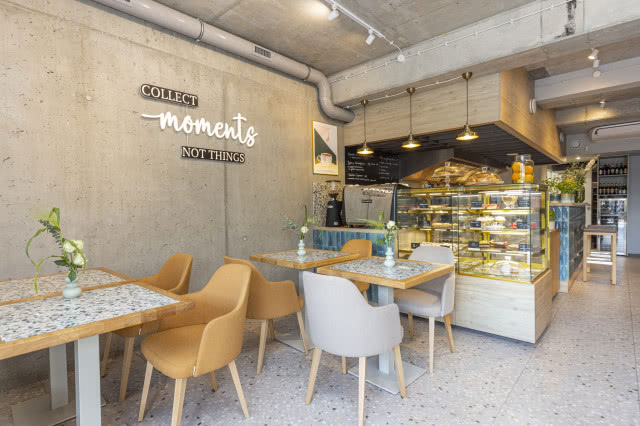 Kawiarnia z lastryko na podłodze i betonową ścianą