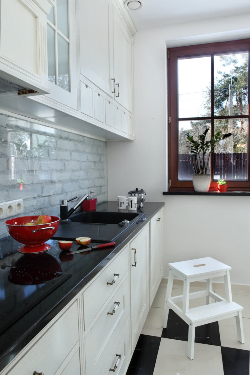 Czarno-białą kuchnię ożywiają czerwone akcenty