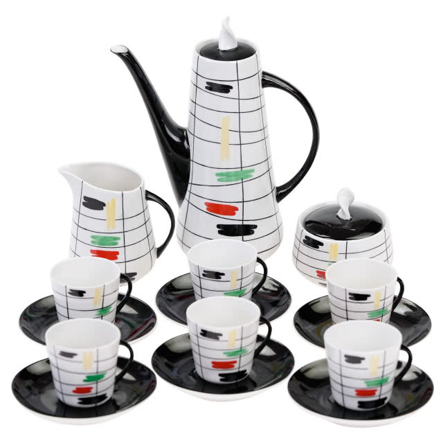 czarne spodki, filiżanki, mlecznik i dzbanek w kolorach białym, czerwonym, zielonym, w paski