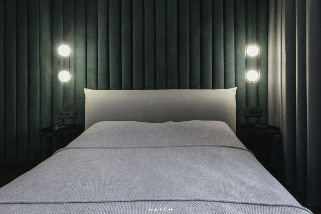 sypialnia, duże łóżko, zagłowie w kolorze butelkowej zieleni, dwa czarne stoliki nocne