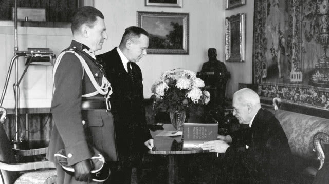 fotografia czarno-biała,  prezydent siedzi, stoi dwóch mężczyzn, jeden w wojskom ubraniu