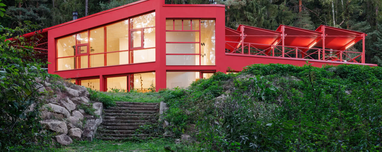 Czerwony dom w środku lasu. Stalowa elewacja robi wrażenie