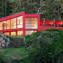 Czerwony dom w środku lasu. Stalowa elewacja robi wrażenie