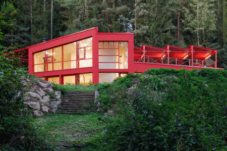 Czerwony dom w środku lasu. Stalowa elewacja robi wrażenie