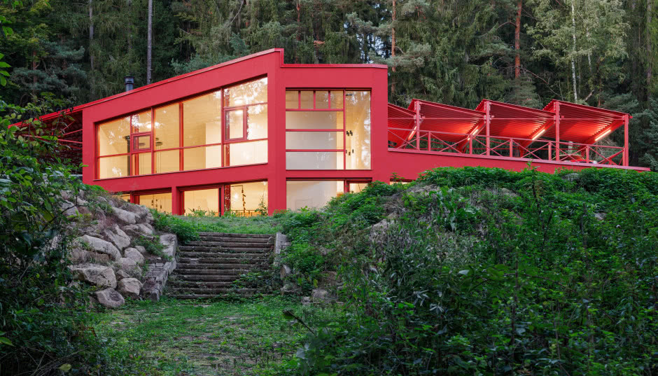 Czerwony dom w środku lasu. Stalowa elewacja robi wrażenie