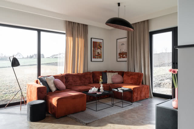 ceglana kanapa w velvetowej tkaninie ustawiona w salonie