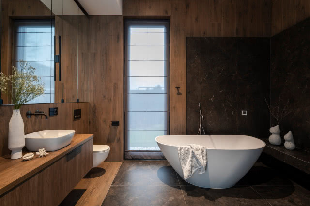 łazienka z drewnem i siedziskiem przy wannie