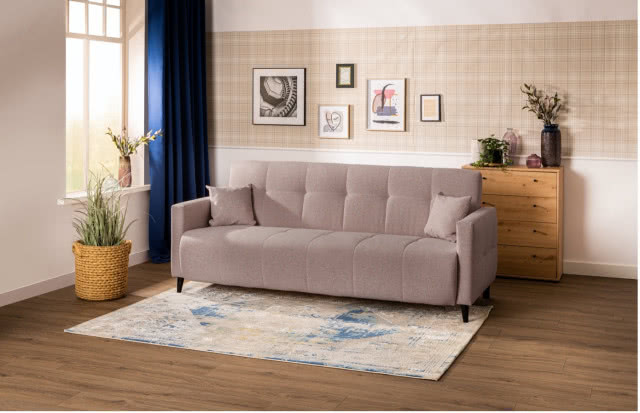 różowa kanapa, dywan, komoda, kwiaty, obrazy, wazon z kwiatami, dywan, drewniana podłoga