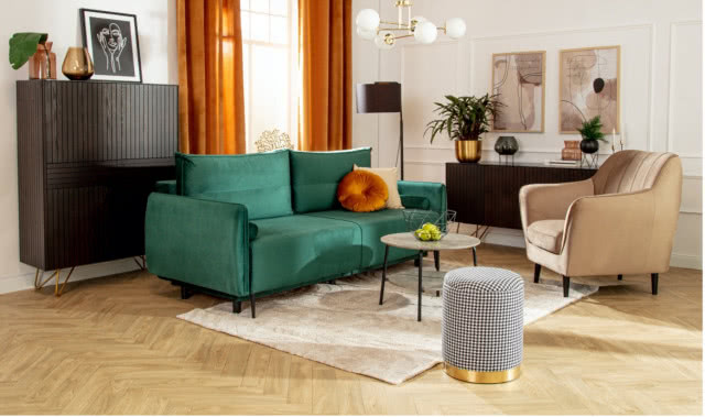 zielona kanapa, puf, fotel, dywan, komoda, lampa podłogowa, obrazy, kwiaty, wazony, lampa sufitowa