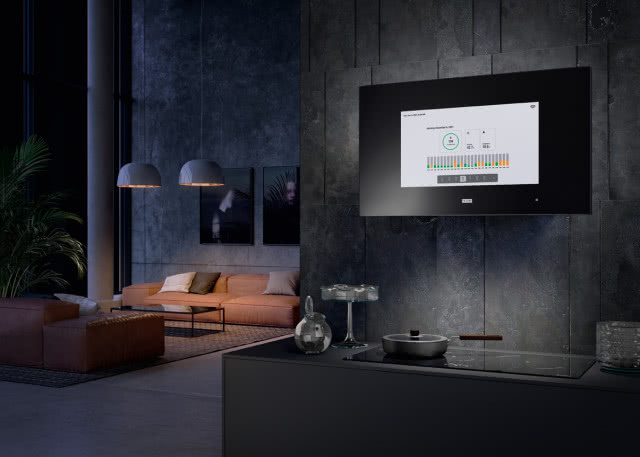 okap, płyta indukcyjna, patelnia, salon, kanapa, oświetlenie sufitowe, stolik kawowy