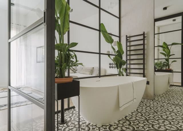 Przeszklona łazienka z wanną przy sypialni