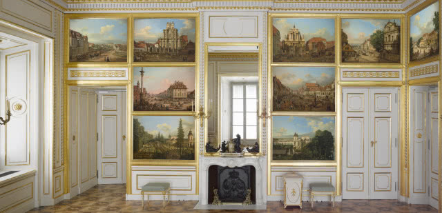 wiszące jeden nad drugim weduty, pośrodku kominek z lustrem