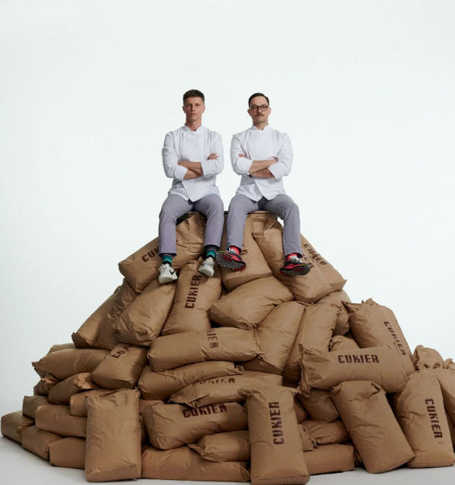 Panowie siedzący na górze utworzonej z worków cukru