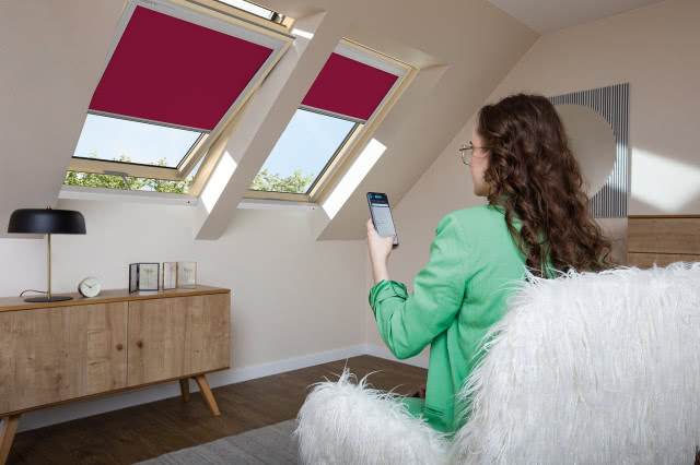 rolety w kolorze viva magenta, okna dachowe, komoda, fotel