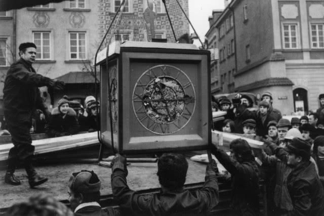 zdjęcia archiwalne, mężczyźni podnoszący zegar zygmuntowski