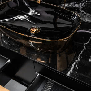 umywalka w kolorze czarnym ze złotym obramowaniem, blat z czarnego marmuru z białym użyleniem