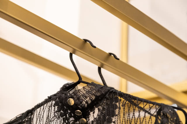 Garderoba, złote drążki na wieszaki z ubraniami
