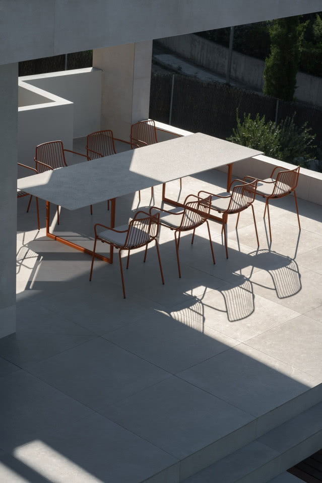 widok z góry na stół i czerwone krzesła ogrodowe
