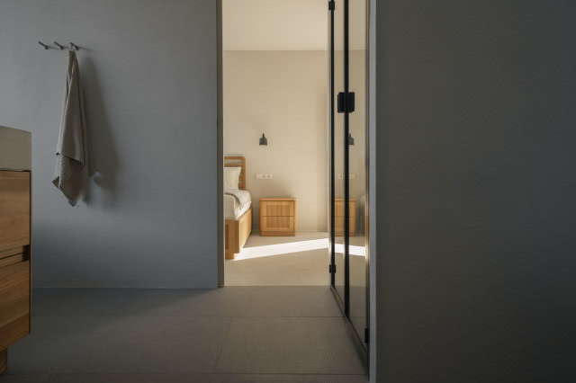 czarna rama prysznica, w tle widok na sypialnię