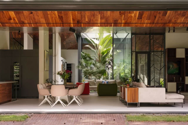 Salon z otwieranym dachem i wielkimi przeszkleniami w domu w Konstancinie - wnętrze przenika się z ogrodem