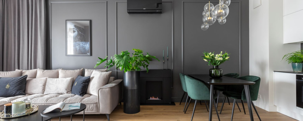 Przytulne wnętrze z antracytową ścianą i biokominkiem w roli głównej