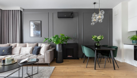 Przytulne wnętrze z antracytową ścianą i biokominkiem w roli głównej