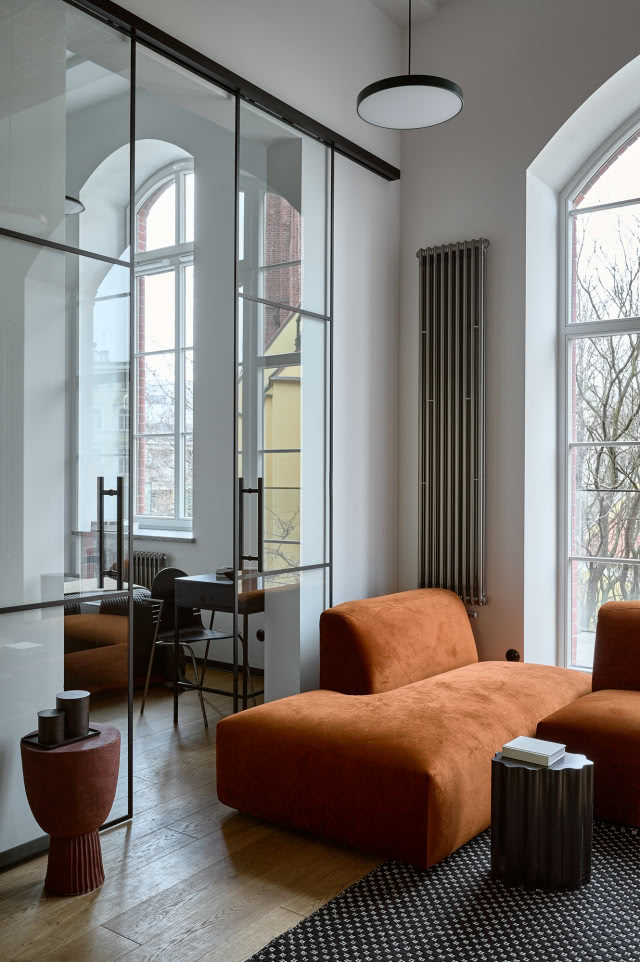 loftowy salon z dużym oknem w kamienicy