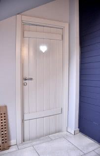 Drewniane drzwi do toalety z wyciętym serduszkiem