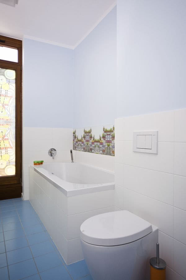 Biała łazienka z niebieską podłogą.