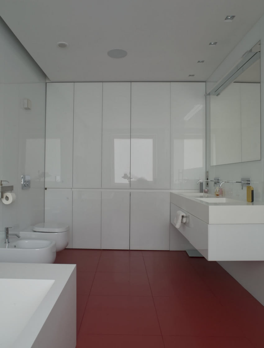 Biała łazienka z czerwoną podłogą.