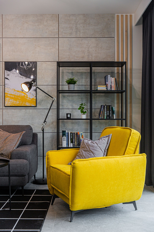 żółty fotel w salonie z szarą ścianą