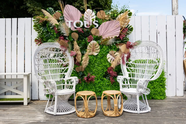 Rattanowe, białe fotele na tle kwiatowej dekoracji