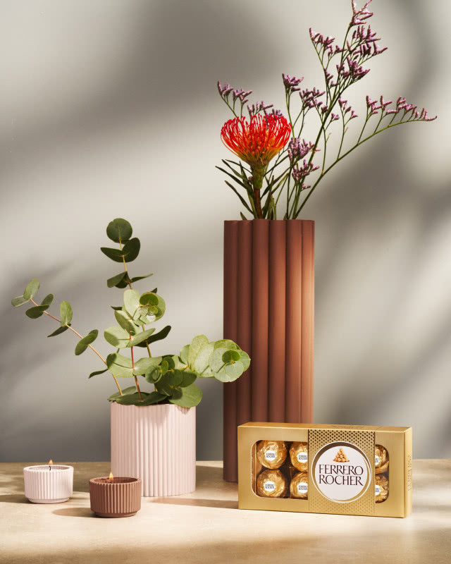 wazon z kwiatami, praliny ferrero rocher, świece zapachowe