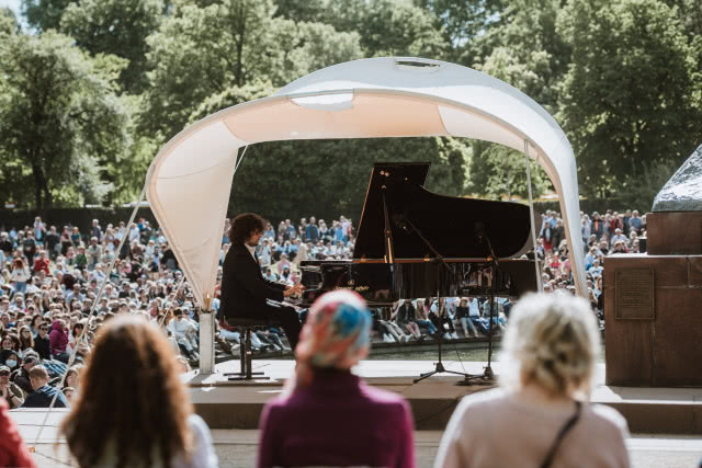 widok na namiot, na pierwszym planie dwie siedzące kobiety