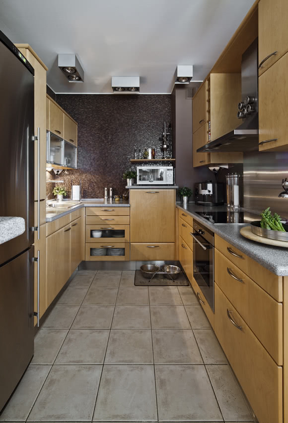 Ciemny brąz ścian równoważą jasne fronty szafek...