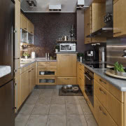 Ciemny brąz ścian równoważą jasne fronty szafek...