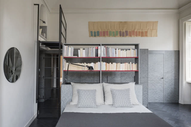 łóżko z zagłówkiem w postaci półek z książkami