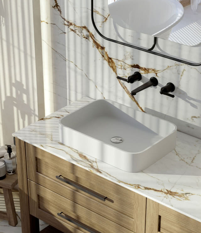 naturalny kamień na ścianie i blat, drewniane meble łazienkowe, umywalka, czarna bateria podtynkowa, lustro, stołek