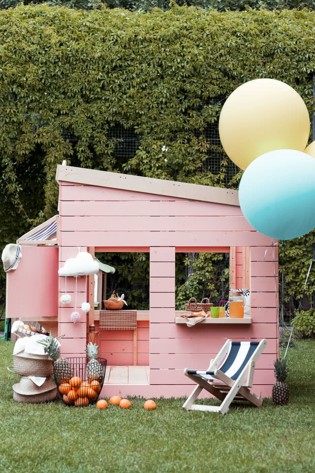 Drewniany różowy domek ogrodowy dla dzieci, balony, pomarańcze, krzesło składane