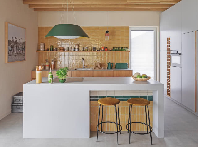 kuchnia z wyspą i pomarańczowymi płytkami