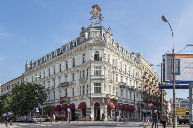 budynek zabytkowy z wejściem do pijalni czekolady, na górze neon chłopca na zebrze